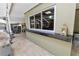This outdoor kitchen features a stone floor, stainless steel grill and a granite countertop overlooking the landscaped yard at 2872 Hammock Dr, Plant City, FL 33566