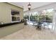 This outdoor kitchen features a stone floor, stainless steel grill and sink area overlooking the pool and landscaped yard at 2872 Hammock Dr, Plant City, FL 33566
