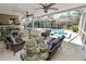 This outdoor living space features stone floors, a fireplace, seating area, and overlooks the pool and landscaped yard at 2872 Hammock Dr, Plant City, FL 33566