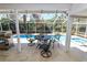 Charming screened patio featuring a wrought iron dining set and outdoor grilling area with a view of the pool at 2872 Hammock Dr, Plant City, FL 33566