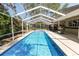 Resort-style long screened in pool, outdoor kitchen, and backyard patio offer outdoor entertainment and relaxation at 2872 Hammock Dr, Plant City, FL 33566
