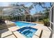 Relaxing screened-in pool and jacuzzi area with tiled decking and lush landscaping for backyard enjoyment at 2872 Hammock Dr, Plant City, FL 33566