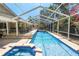 A long refreshing screened-in pool with jacuzzi and tanning ledge alongside an outdoor kitchen and bar at 2872 Hammock Dr, Plant City, FL 33566
