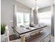 Bright dining room with a modern table set, sliding glass doors, and elegant lighting fixture at 6957 161St E Ter, Parrish, FL 34219