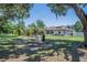 Lush backyard featuring a screened enclosure, palm trees, and an expanse of green space at 7608 Franklin Rd, Plant City, FL 33565