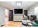 Bedroom with hardwood floors, a television, and an open doorway to another room at 7608 Franklin Rd, Plant City, FL 33565