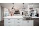 Bright kitchen featuring a stainless steel farmhouse sink, white cabinetry, and pendant lighting at 7608 Franklin Rd, Plant City, FL 33565