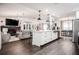 Open-concept living space with modern island, hardwood floors, and seamless flow to living and dining areas at 7608 Franklin Rd, Plant City, FL 33565