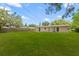 A view of the backyard from the corner of the house, revealing a large open green space at 1018 Briarwood Ave, Tampa, FL 33613