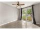 The bedroom features a ceiling fan and a large window with gray curtains and views of the lawn at 1018 Briarwood Ave, Tampa, FL 33613