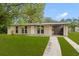 Welcoming home with a lush green lawn, and a convenient attached carport at 1018 Briarwood Ave, Tampa, FL 33613