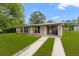 Inviting home featuring a spacious lawn and an attached carport at 1018 Briarwood Ave, Tampa, FL 33613