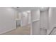 Hallway with neutral carpeting, leading to the laundry room with a washer and dryer at 2622 Lantern Hill Ave, Brandon, FL 33511