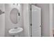 Well-lit powder room featuring an oval mirror and pedestal sink, conveniently located at 2622 Lantern Hill Ave, Brandon, FL 33511