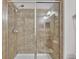 Modern tiled shower featuring glass sliding doors and updated fixtures at 2622 Lantern Hill Ave, Brandon, FL 33511
