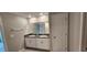 Bright bathroom features a double sink vanity with granite countertop, complemented by a large mirror and white cabinetry at 3188 Nubbin Ridge Ln, Zephyrhills, FL 33540