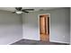 A carpeted bedroom featuring a ceiling fan and open doorway that leads to a bathroom with tiled flooring at 3188 Nubbin Ridge Ln, Zephyrhills, FL 33540