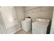 Laundry room with tile flooring featuring a washer, dryer and wire shelving at 3188 Nubbin Ridge Ln, Zephyrhills, FL 33540