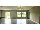 Bright living room featuring tile floors, a ceiling fan, and sliding glass doors with backyard views at 3188 Nubbin Ridge Ln, Zephyrhills, FL 33540