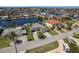 Aerial view of a waterfront home with lush landscaping, circular driveway, and neighboring waterway at 3626 Corsair Ct, New Port Richey, FL 34652
