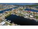 Aerial view of a residential community with waterfront homes, docks, and canal access to the ocean at 3626 Corsair Ct, New Port Richey, FL 34652