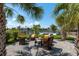 Waterfront backyard featuring a large paver patio, comfortable seating, and mature palm trees at 3626 Corsair Ct, New Port Richey, FL 34652