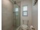 Walk-in shower featuring neutral tiles, glass door, and an updated shower head at 3626 Corsair Ct, New Port Richey, FL 34652