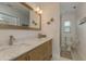 Bathroom featuring a marble countertop vanity, framed mirror, and walk-in shower at 3626 Corsair Ct, New Port Richey, FL 34652