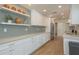 Bright kitchen featuring white cabinets, a stainless steel refrigerator, and floating shelves at 3626 Corsair Ct, New Port Richey, FL 34652