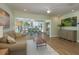 Open-concept living and dining area with wood floors and sliding glass doors to the outdoors at 3626 Corsair Ct, New Port Richey, FL 34652