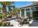 Outdoor patio area with seating, palm trees, and sliding glass doors at 3626 Corsair Ct, New Port Richey, FL 34652