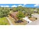 Aerial view of home featuring a neutral stucco exterior, mature trees, and a long driveway at 5370 Boxtree Ct, Dade City, FL 33523