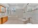 Spacious tile bathroom featuring a tub, vanities, and dual toilet at 5370 Boxtree Ct, Dade City, FL 33523