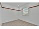 Bright, empty bedroom with decorative trim, tile floor, and ample natural light through the window at 5370 Boxtree Ct, Dade City, FL 33523