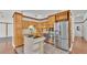 Bright kitchen featuring stainless steel appliances, cooktop island and wooden cabinets at 5370 Boxtree Ct, Dade City, FL 33523