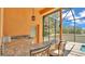 Outdoor kitchen featuring granite countertops, a sink, bar seating, and a view of the pool at 5370 Boxtree Ct, Dade City, FL 33523