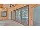 Covered patio features travertine flooring, access to screened-in pool and doors to the interior at 5370 Boxtree Ct, Dade City, FL 33523