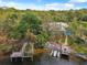 Aerial view of waterfront property featuring boat docks, lush greenery, and serene water views at 5903 Cachette De Riviera Ct, New Port Richey, FL 34655