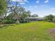 Large grassy backyard surrounded by mature trees, offering privacy and space for outdoor enjoyment and recreation at 5903 Cachette De Riviera Ct, New Port Richey, FL 34655