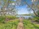 Waterfront backyard view of large pond with dock and chairs; great space for enjoying nature at 5903 Cachette De Riviera Ct, New Port Richey, FL 34655