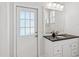 Bathroom featuring a white vanity, black countertop, a mirror, and a door leading to the outside at 5903 Cachette De Riviera Ct, New Port Richey, FL 34655