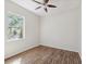 Bedroom with vinyl floors, ceiling fan, and a large window with lush scenery at 5903 Cachette De Riviera Ct, New Port Richey, FL 34655