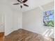 Bright bedroom with vinyl floors, ceiling fan, and a view of tropical outdoors at 5903 Cachette De Riviera Ct, New Port Richey, FL 34655