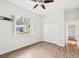 A bright bedroom with vinyl wood floors, closet, ceiling fan, and a view of the outdoors at 5903 Cachette De Riviera Ct, New Port Richey, FL 34655