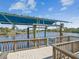 Waterfront boat dock with boat lift surrounded by beautiful views of the water and landscape at 5903 Cachette De Riviera Ct, New Port Richey, FL 34655