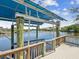 Waterfront wooden dock with boat lift surrounded by beautiful open water and landscape views at 5903 Cachette De Riviera Ct, New Port Richey, FL 34655