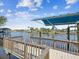 Waterfront wooden boat dock with wooden railing and canopy boat lift for ease in your water activities at 5903 Cachette De Riviera Ct, New Port Richey, FL 34655
