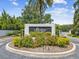 Welcoming Riviera community entrance with lush landscaping and a beautiful sign, showcasing the neighborhood's appeal at 5903 Cachette De Riviera Ct, New Port Richey, FL 34655