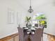 Cozy dining room highlighting hardwood floors, light fixtures, and a bay window view at 5903 Cachette De Riviera Ct, New Port Richey, FL 34655