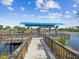 View of a waterfront boat dock with a wooden railing and boat lift in a gorgeous waterway setting at 5903 Cachette De Riviera Ct, New Port Richey, FL 34655